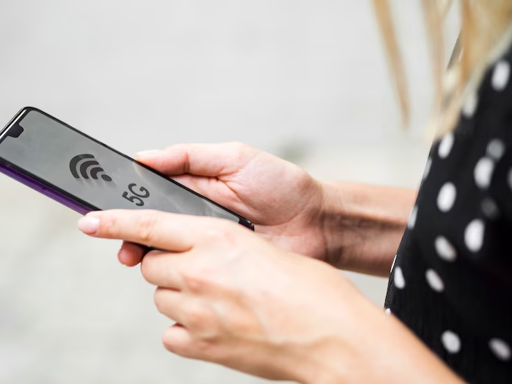 A woman holding a phone showing the 5G WiFi logo