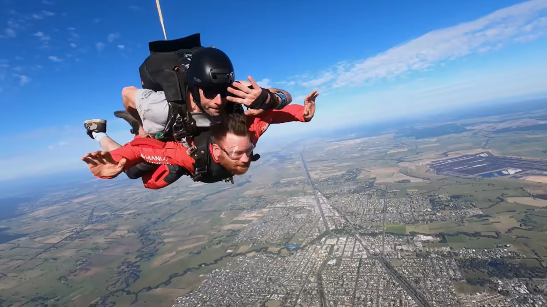 tandem skydiving with a parachute over the land and city