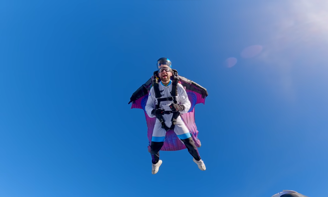 tandem skydiving - two men flying above the land and a clear blue sky