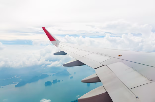 Airplane wing above sea level and islands