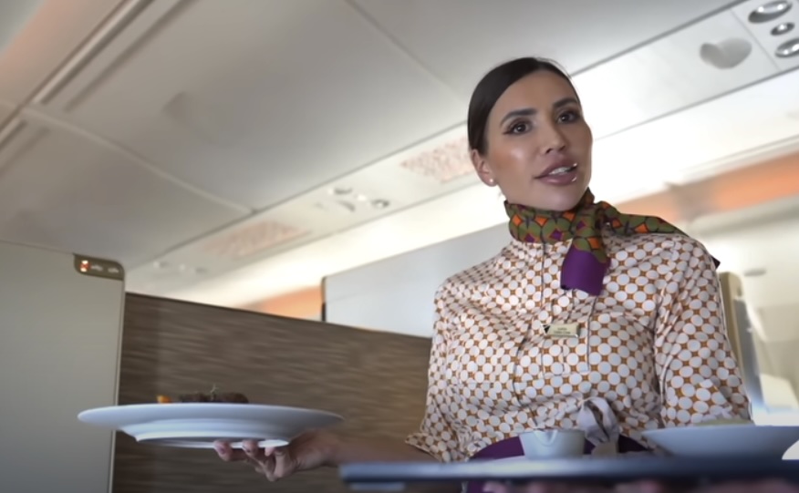 Flight attendant serving meal